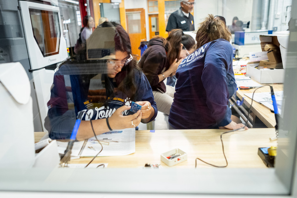 female student holding a device while researching